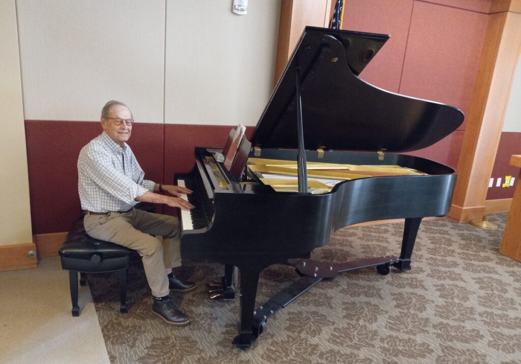 Freese plays the baby grand he donated to Holly Creek