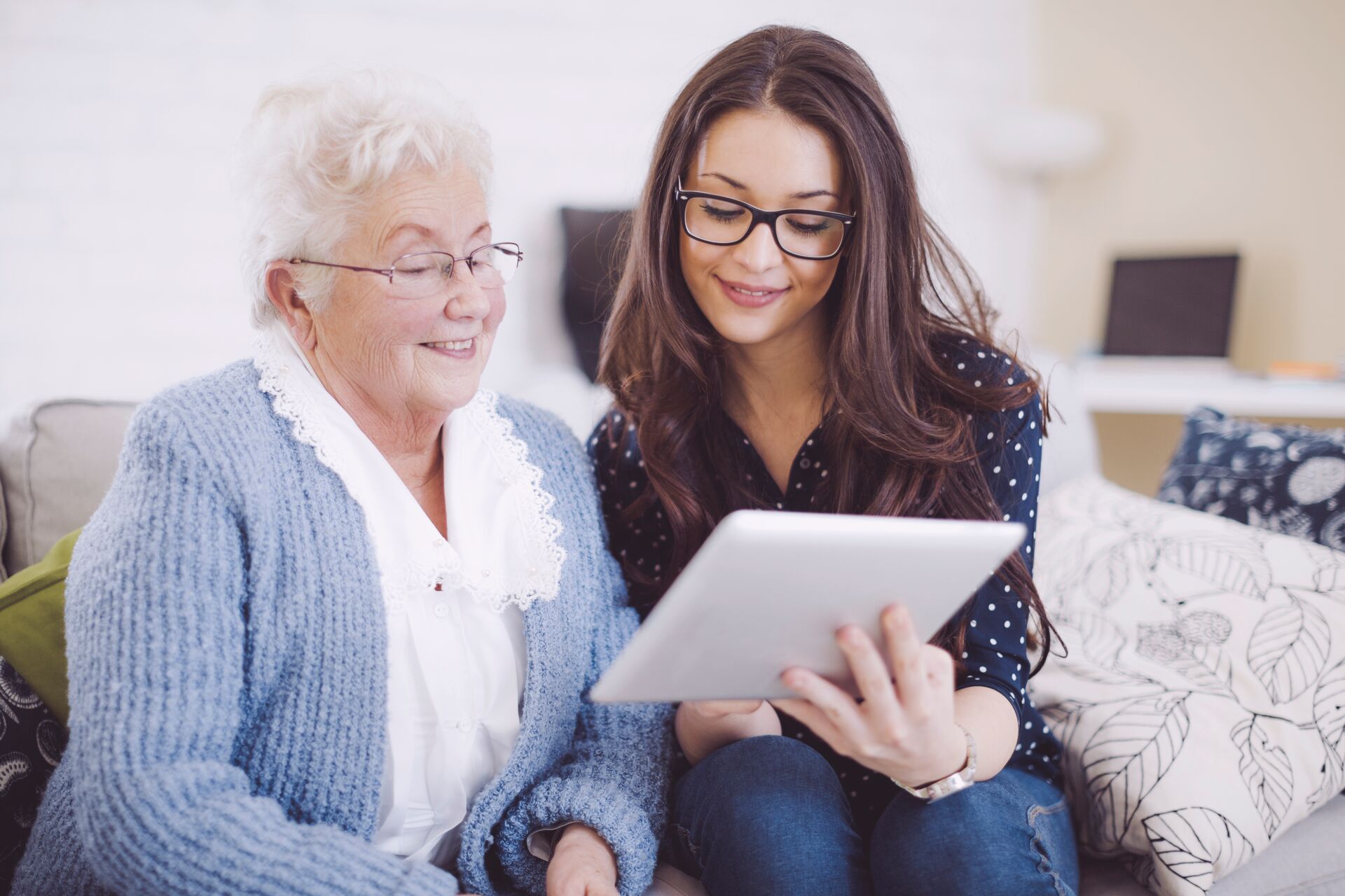 senior resident and caregiver viewing a tablet