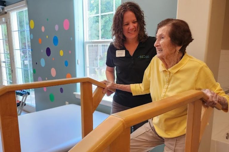 PT assisting rehab guest with stair exercises