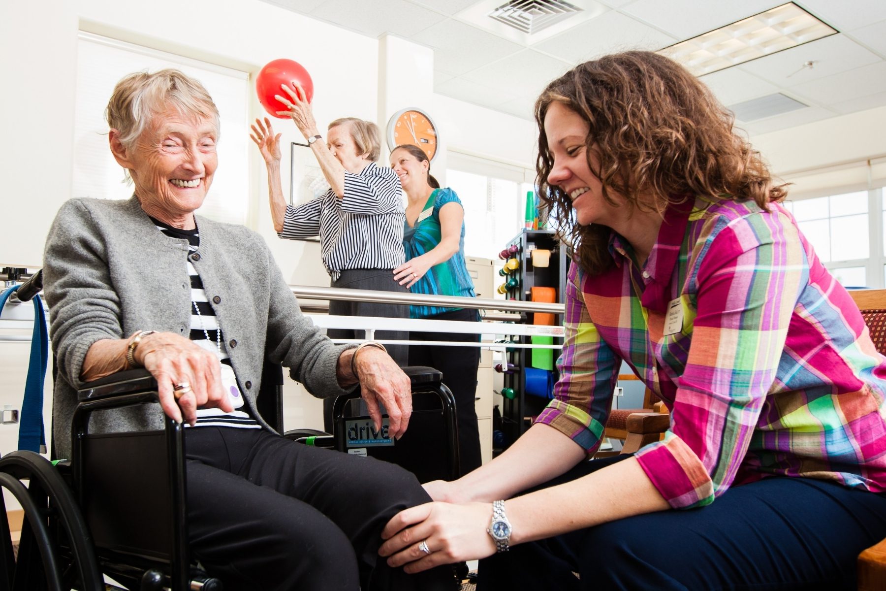 physical therapist and residents in rehab gym landscape