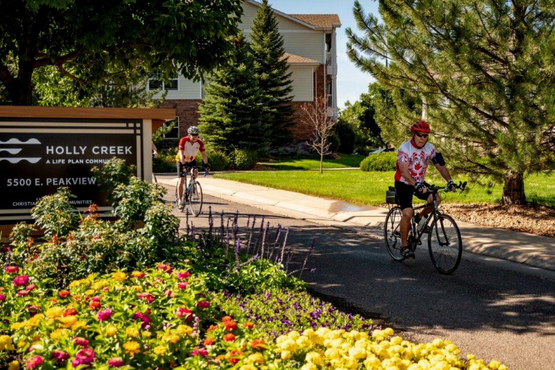 residents riding bikes near holly creek sign landscape