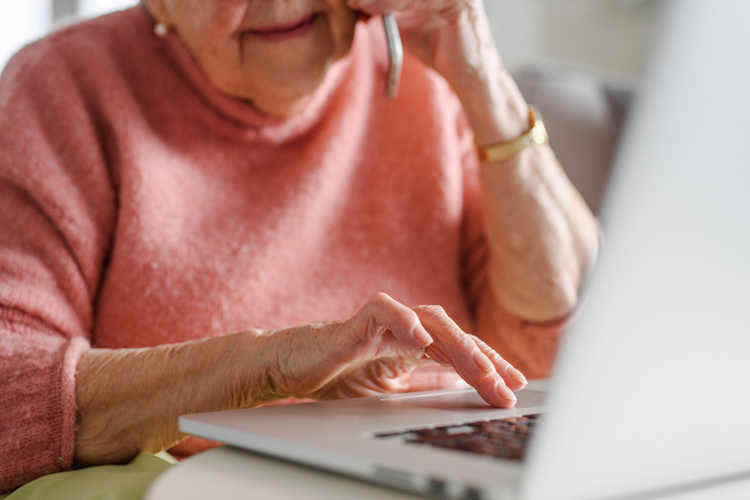 holly creek senior woman using phone and laptop