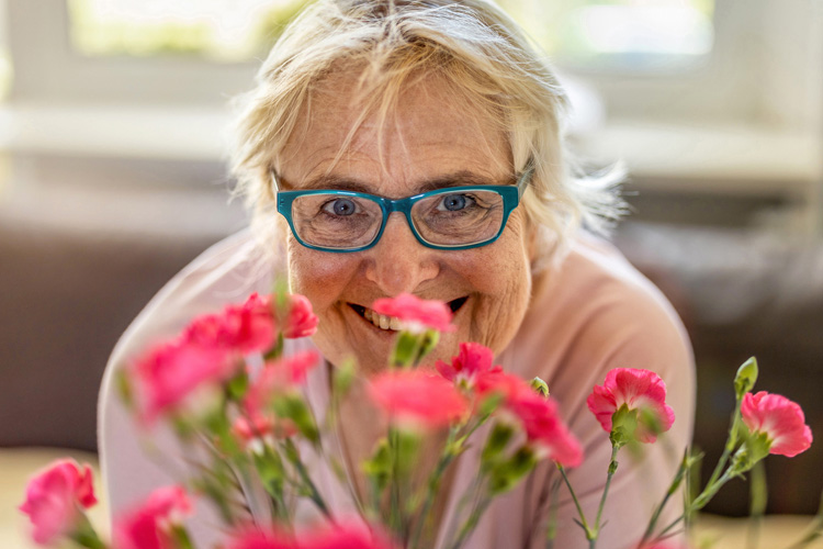 holly creek woman smiling behind bouquet of flowers holly creek woman smiling behind bouquet of flowers