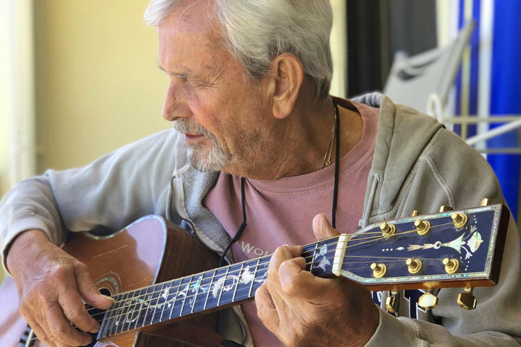 holly creek senior man playing guitar