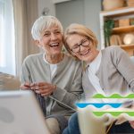holly creek two senior woman laughing while working on crafting