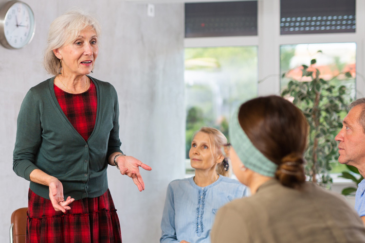 holly creek senior woman speaking or teaching in a group holly creek senior woman speaking or teaching in a group