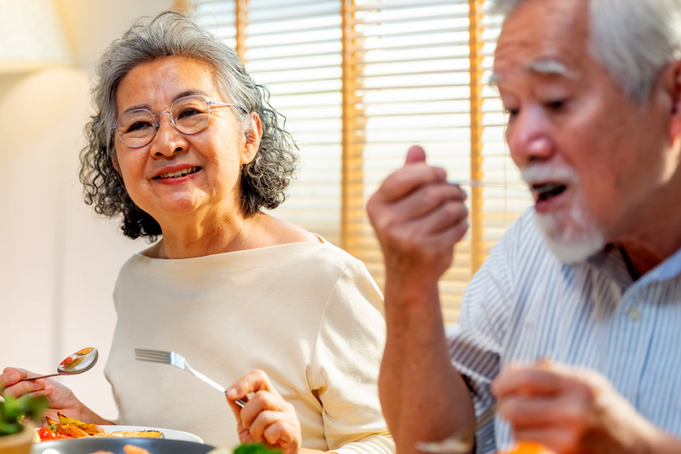 holly creek senior couple eating dinner with others holly creek senior couple eating dinner with others