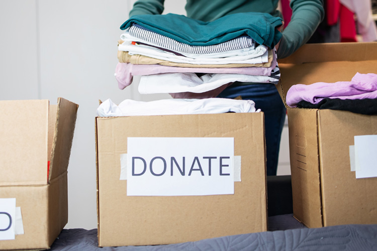 holly creek person putting clothes into a donate box